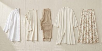 Flat lay of summer wardrobe essentials: linen shirt, wide-leg trousers, floral midi skirt, and ivory kimono